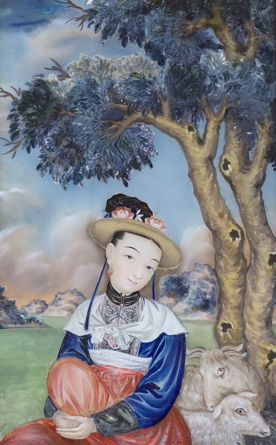 A mid 19th century Chinese reverse painting on glass, depicting a figure and goats seated beneath a tree, 38 x 23cm